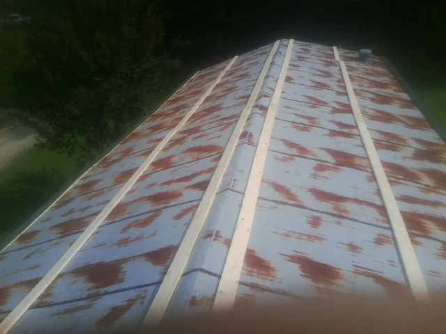 Rusted metal roof panels with new wood purlins before replacement — Storm Damage Roof Repair in Fernandina Beach by Roofing Brothers