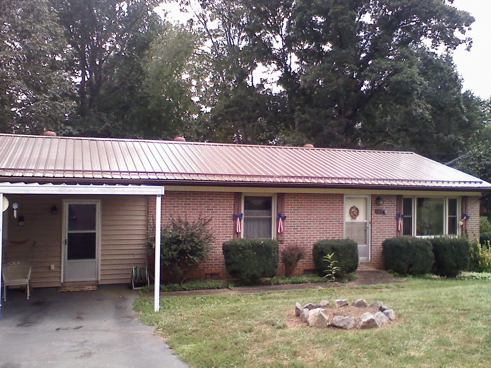 Bronze metal roof and carport on a brick ranch home — Roof Repair work by our crew in Fernandina Beach